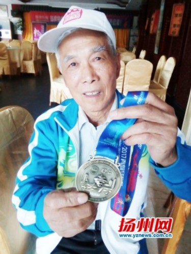涂所德展示获得的马拉松奖牌