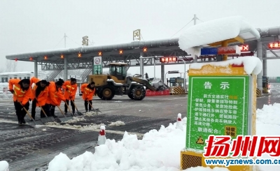 蜀冈收费站工作人员正在除雪破冰。庄文斌张震宇摄