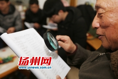 吴教授年事已高，需用放大镜才能看得清教材