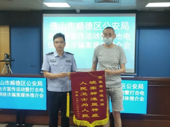 事主周生（图右）今日向顺德警方送来锦旗。