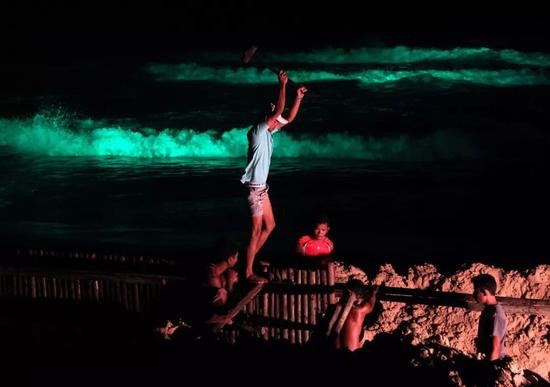 2011年6月10日，泰国普吉岛上，泰国和缅甸工人夜间在沙滩上打木桩，以阻止汹涌的海浪侵袭海边的餐馆。 新华社/EPA欧新