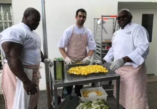 ▲在这张网上走红的照片中,拉什(左)正与同事一起准备食物。