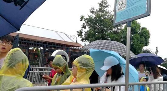 7月22日9点15分，台风“安比”正在接近，上海迪士尼乐园门口，游客正排队安检。 网友供图