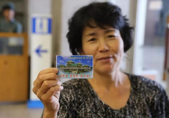 ▲7月17日，在朝鲜平壤人民大学习堂，一名朝鲜读者展示其读者证。
