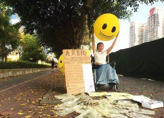 在轻轨站附近卖笑筹钱的朱娅。 蒋宇 图