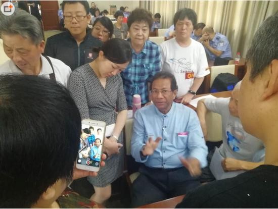 家属与马来西亚航空公司代表Fuwa(音译)在商讨增加家属八月份去马来西亚与马政府和调查官员继续见面谈判的名额。(拍摄:环球时报英文版记者 胡雨薇)