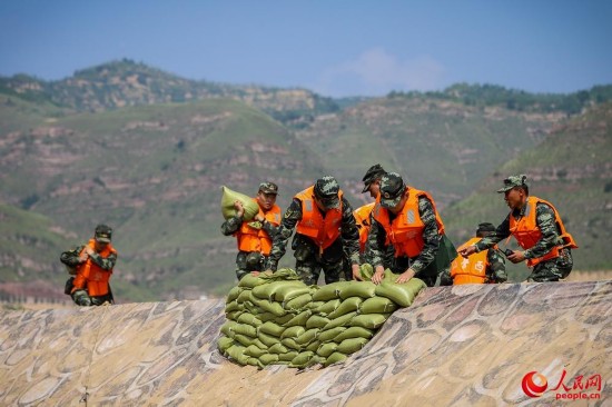 官兵运送沙袋填补决口。（曹正玉摄）