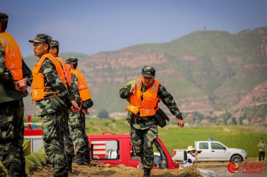 官兵快速运送沙袋。（曹正玉摄）