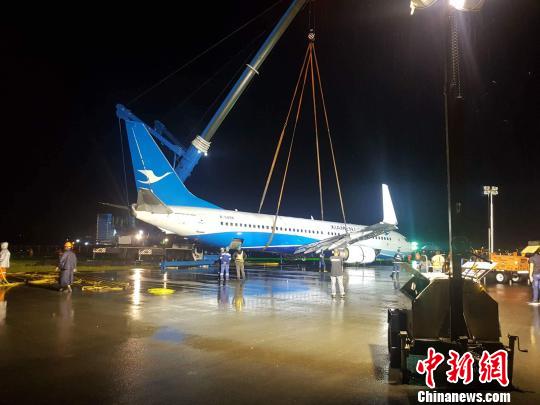 18日凌晨6时13分,马尼拉国际机场(NAIA)使用起重机及平台车将厦航降落后冲入6/24号跑道外草地的飞机,搬移至指定停放位置。 NAIA媒体中心供图 摄