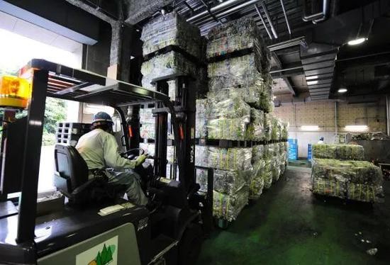 ▲资料图片：在日本东京都港区资源垃圾处理中心，工作人员运送初步处理好的塑料瓶。