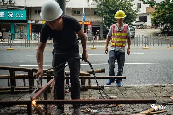 △ 深圳坂田某街道，刘蒙的日结工作是帮助城管拆除街边的广告牌。他们这些找来的“临时工”因为没有技术，大多是打打杂，维持一下现场的秩序，8个小时120元钱。