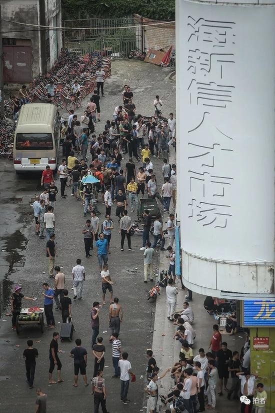 △ 8月14日早晨5点40分，海新信人才市场旁的街道上，已经围满了前来“抢”薪水日结工作的打工者。这里就是三和人力市场。