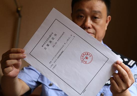 黄百炼展示郴州警方对原民警王斌涉嫌盗窃毒品的立案决定书。  本文图片均为受访者提供