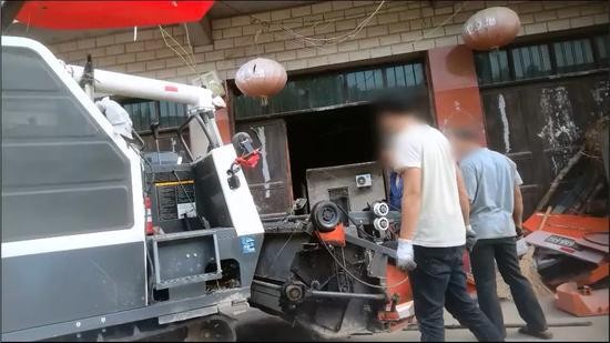 （注：工人正在翻新农机。）