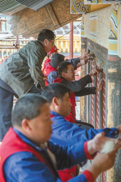 专家刘增玉指导油作学员压麻操作。