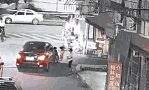 小女孩突然拐弯险入车底 哥哥奋力拍车呼救