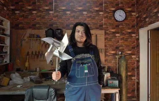 耿帅在展示他制作的不锈钢风车。新京报记者赵蕾 摄