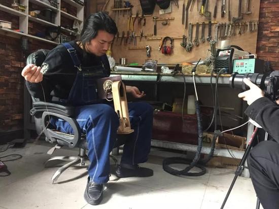 耿帅正在为菜刀手机壳缝制皮套。新京报记者赵蕾 摄