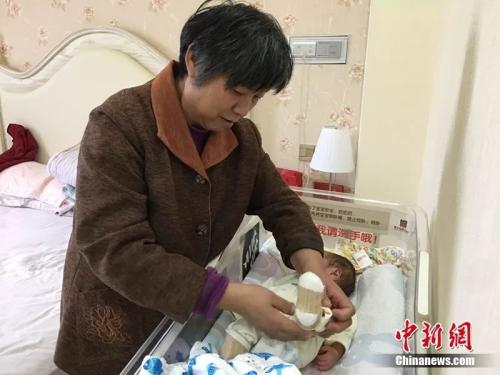 郭庆芳给儿子穿袜子 马芙蓉 摄