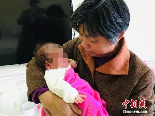 郭庆芳抱着儿子，充满怜爱 马芙蓉 摄