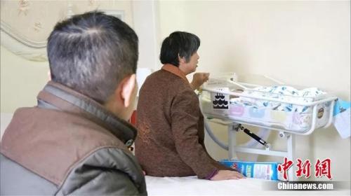 夫妇俩照看孩子 马芙蓉 摄