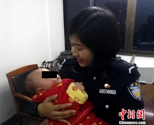 图为：民警照顾婴儿 叶明銮 摄