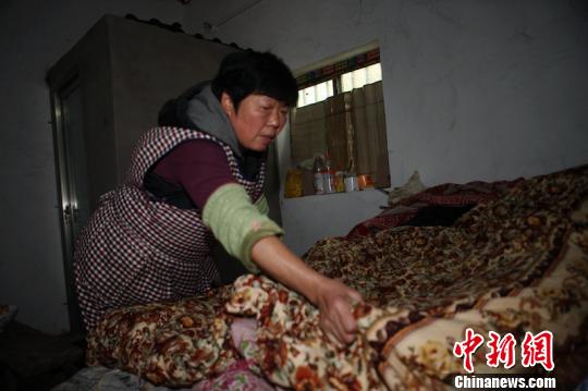 黄华芬为老人整理被褥。　刘林 摄
