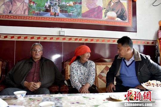 图为谢日布夫妇与县扶贫工作人员交流。　陈文年 摄