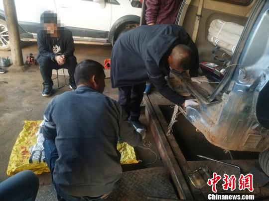 图为工作人员正在检查藏毒车辆 鲁鑫 摄