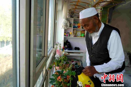图为马贵家里浇花。　吴萍 摄