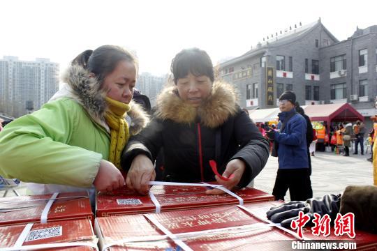 义工为慰问对象发放“雷锋饺子”爱心礼包。　李佩珊 摄