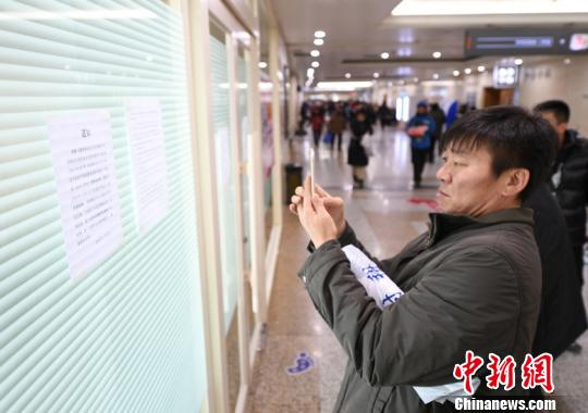 一些有疑惑的民众在关闭的门诊输液区阅读告示。　张瑶 摄