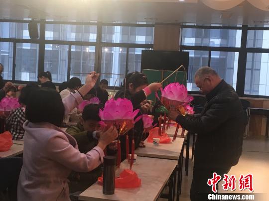 周永健现场教授小朋友制作“莲花灯”。 叶秋云 摄