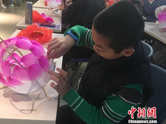 小朋友正在认真糊花瓣。 叶秋云 摄