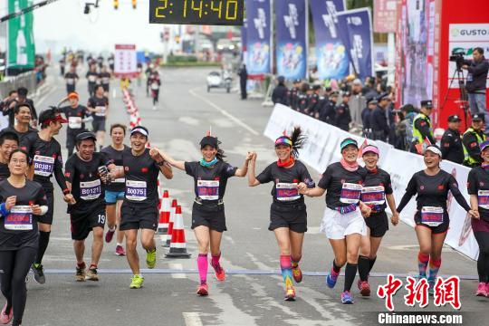 图为选手们手牵手冲过终点。 陈凡 摄