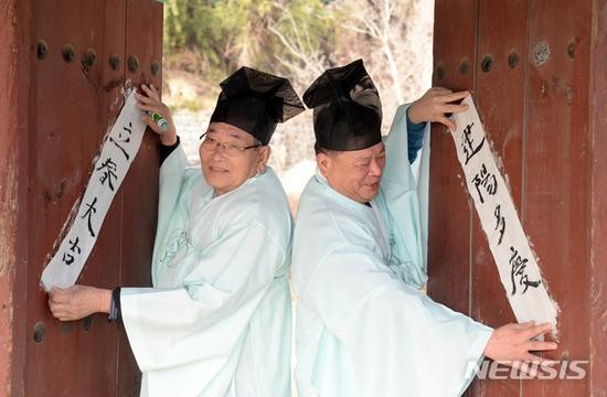 儒生们将对联贴在门上。(纽西斯通讯社)