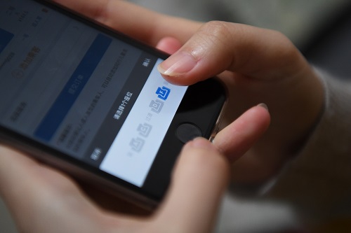 一名旅客通过12306手机APP订购高铁车票并选座。 新华社发