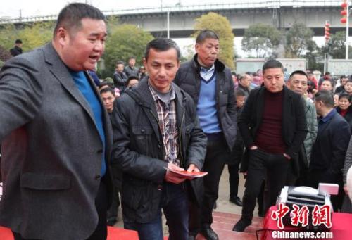 图为招贤村党支部书记李文华（左一）为股东代表发放分红现金。　刘占昆 摄