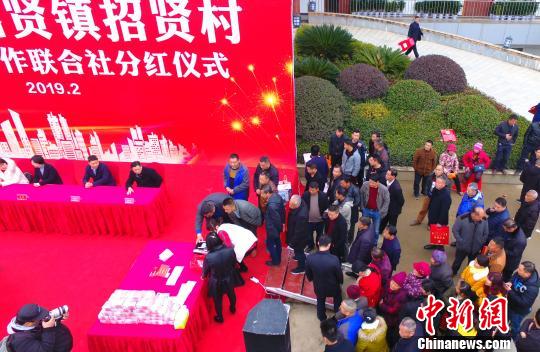  图为现场发放分红现金画面。（无人机拍摄） 刘占昆 摄