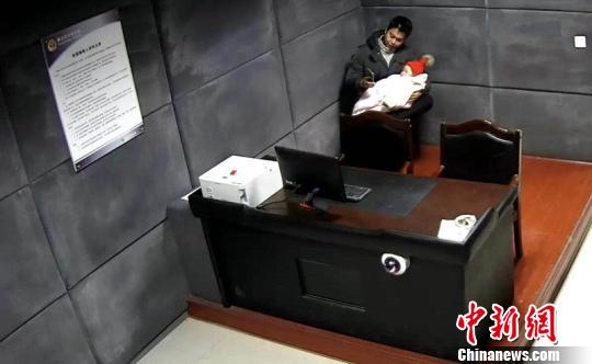 民警抱着孩子，哼歌陪伴入睡。　吴平华　摄