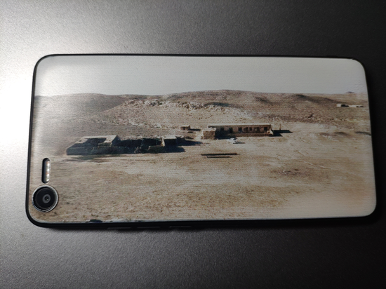    手机壳后盖上打印着牧区老家的照片