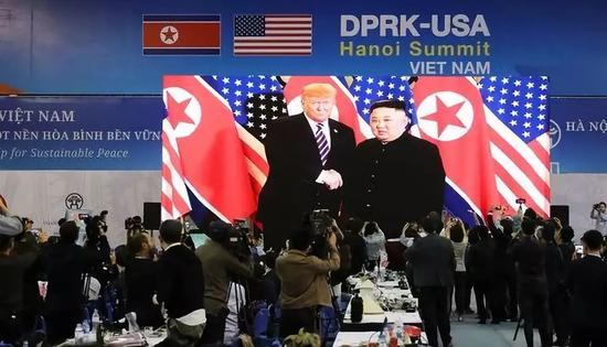 2月27日,在越南首都河内,记者在国际媒体中心观看和拍摄朝鲜最高领导人金正恩(屏幕右侧)与美国总统特朗普会面的电视直播。新华社记者吴晓初摄