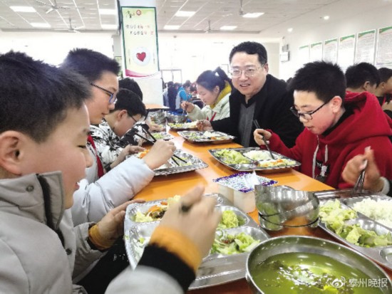 凤凰初级中学校长沙国禅在与初一(1)的学生共同用餐