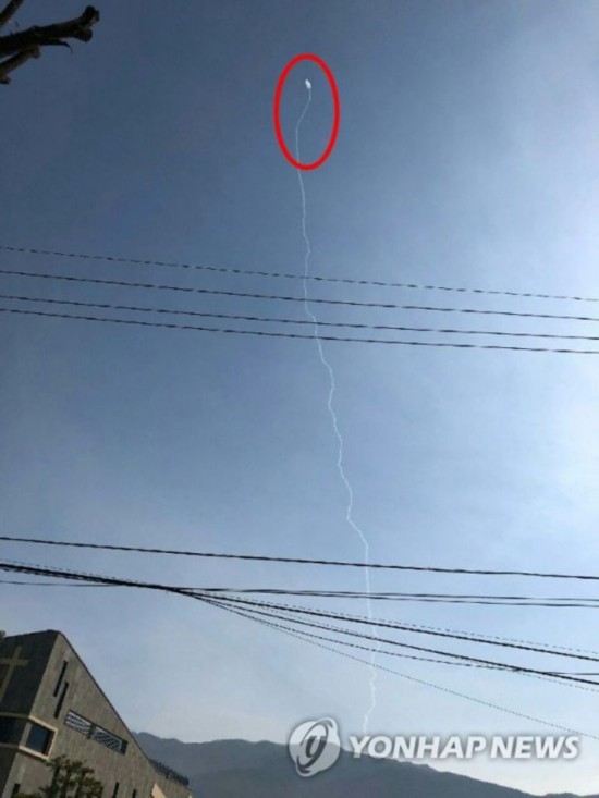 3月18日，在江原道春川市，疑似导弹的飞行物在空中拖出一条长线。（韩联社）