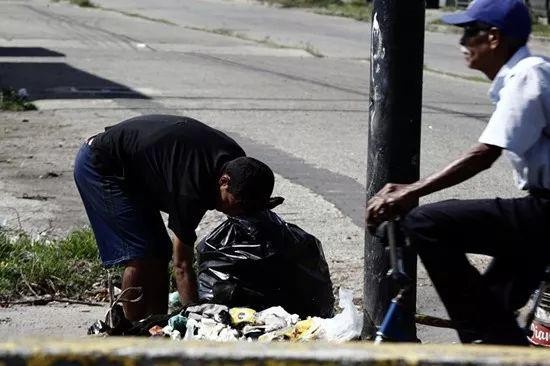委内瑞拉巴伦西亚，当地街头随处可见在垃圾堆中翻找食物的平民 。图IC