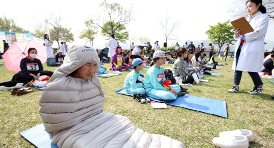 男子钻进睡袋，一脸惬意。（韩国《中央日报》）