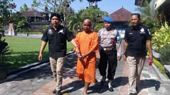嫌疑人Toha(左二)身穿橙色监狱制服,在4月26日新闻发布会后被警察护送到监狱/图据detik新闻