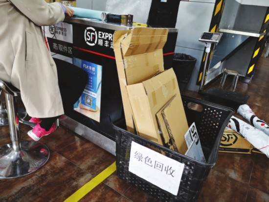 　　一家顺丰网点内柜台旁放着用来回收纸箱的筐，并标注了绿色回收。记者　张博彦摄