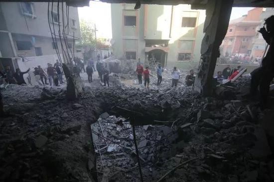 5月5日，在加沙地带拉法，巴勒斯坦人查看遭以军空袭损毁的房屋。新华社发（哈立德&middot;奥马尔摄）