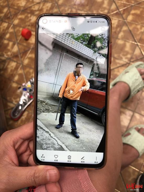 &uarr;小区居民许女士手机拍摄的当时拿着铁棍追打流浪狗的刘飞。